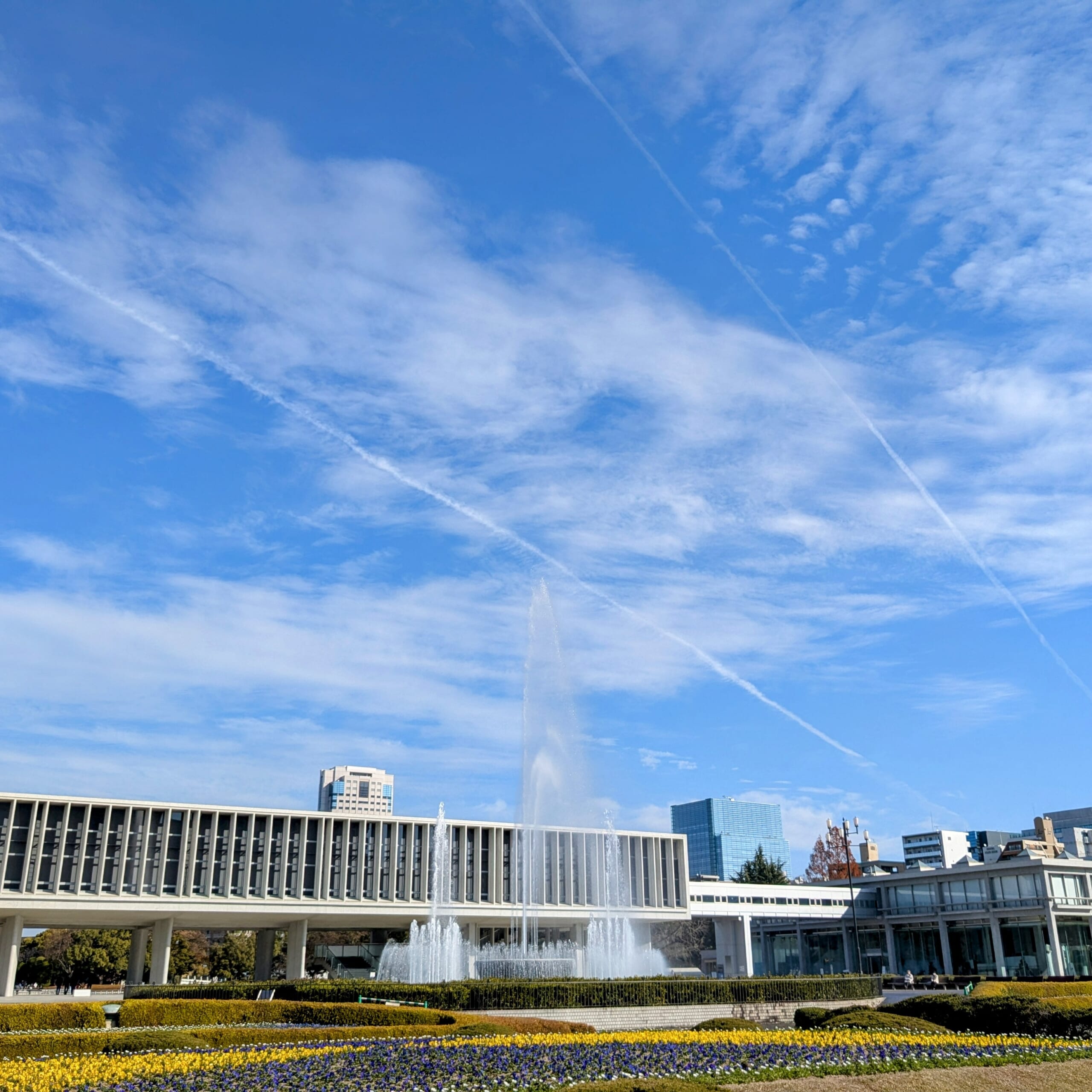 写真 広島平和公園の空 飛行機雲が2本